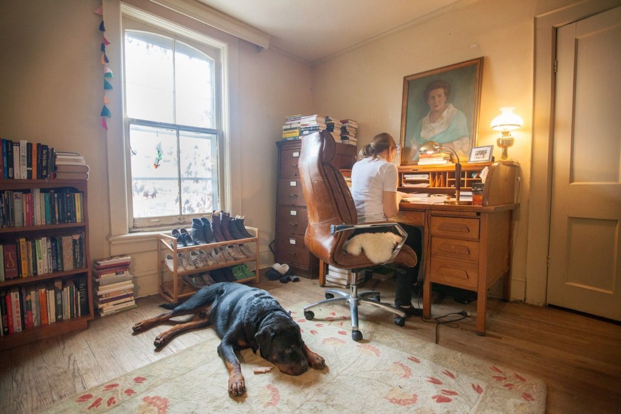 Sheila Heti at her desk with her dog